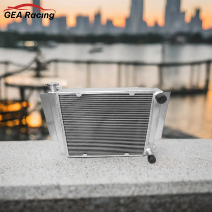 A performance aluminum radiator installed in a clean Mazda RX3 engine bay, showing a perfect fit for a heater-delete setup, ideal for a track car or simplified build.